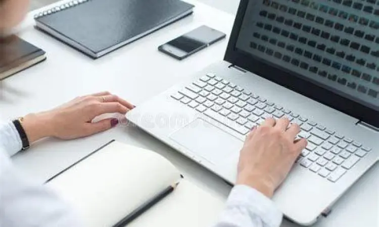 Seseorang sedang mengetik surat lamaran kerja di laptop