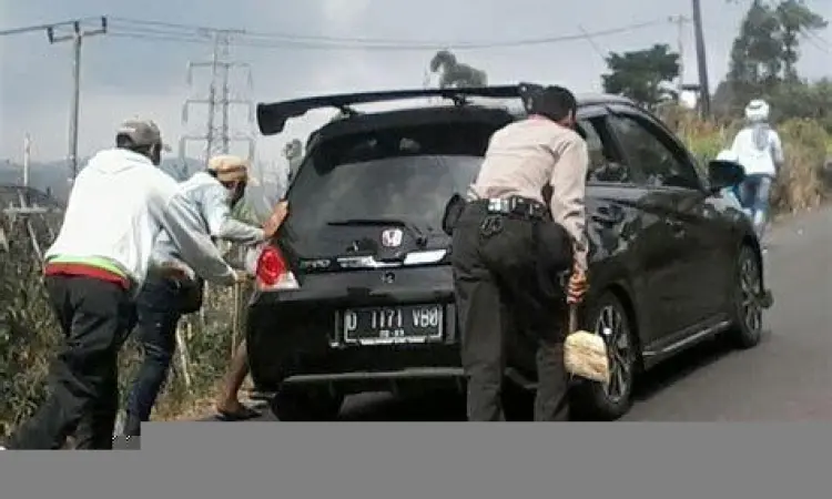 Orang mendorong mobil mogok sebagai contoh usaha