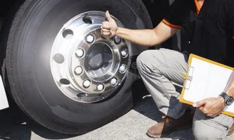 Pengemudi mengecek kondisi ban mobil kantor