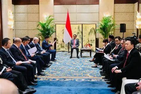 Sinergi Bisnis Indonesia Para eksekutif perusahaan sedang berjabat tangan menandakan kesepakatan merger