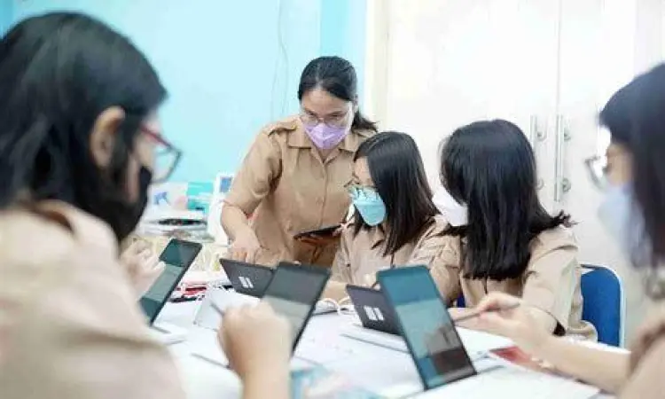 mahasiswa sedang bekerja sama di depan laptop membangun produk digital