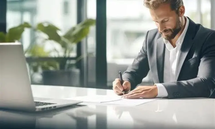 Seseorang sedang menulis strategi bisnis di laptop